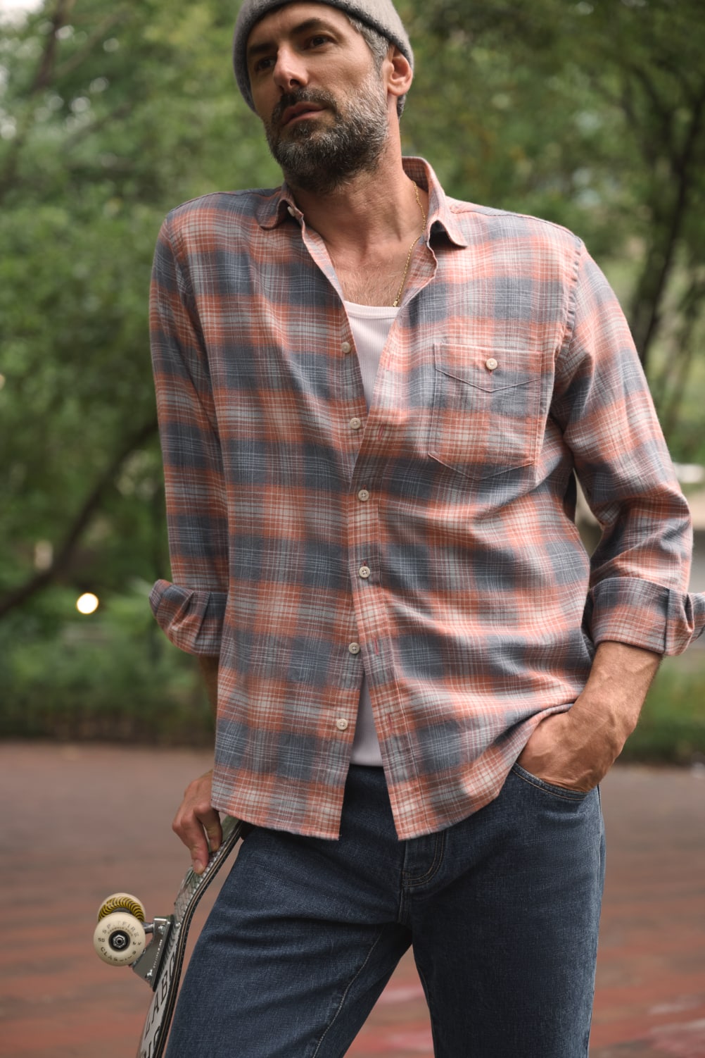 Man casually leaning on skateboard