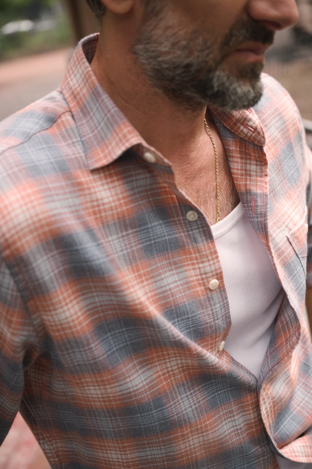 Closeup of unbuttoned salmon-colored flannel shirt