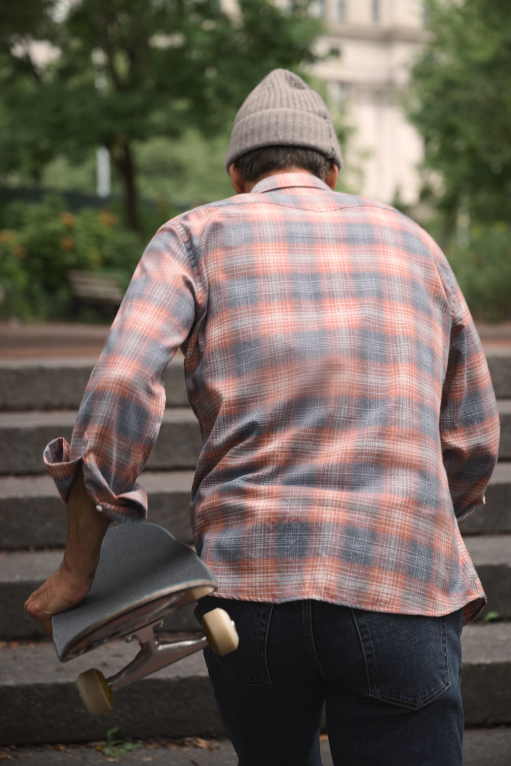 Man facing away from camera, displaying back of a flannel shirt