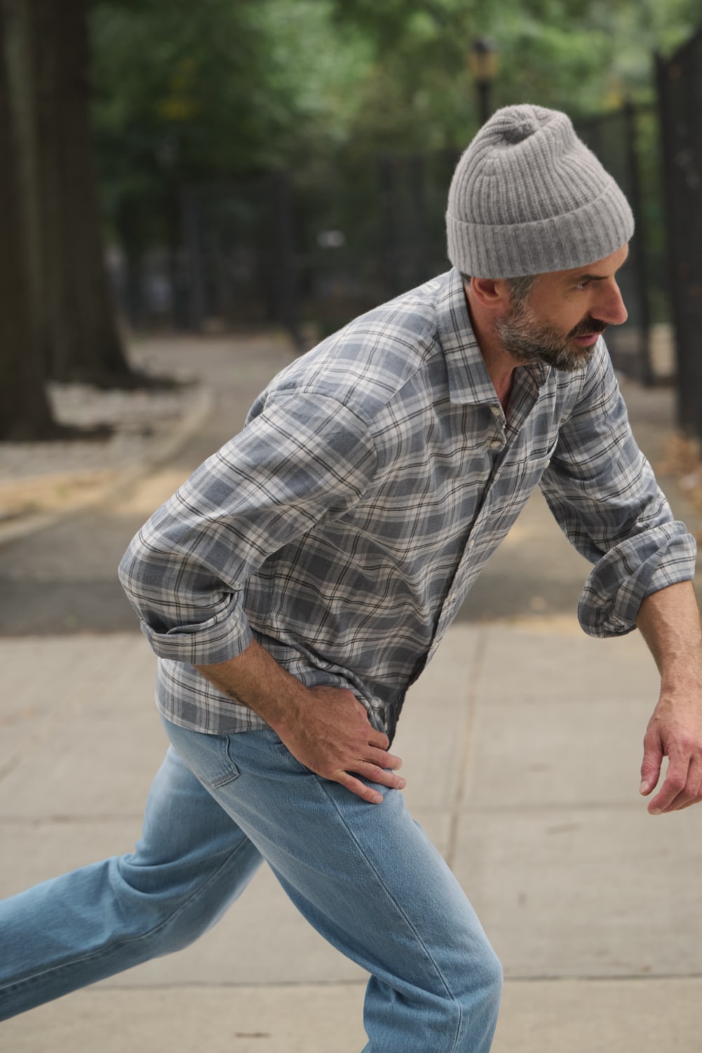 Man skating wearing jeans and slate and grey plaid shirt