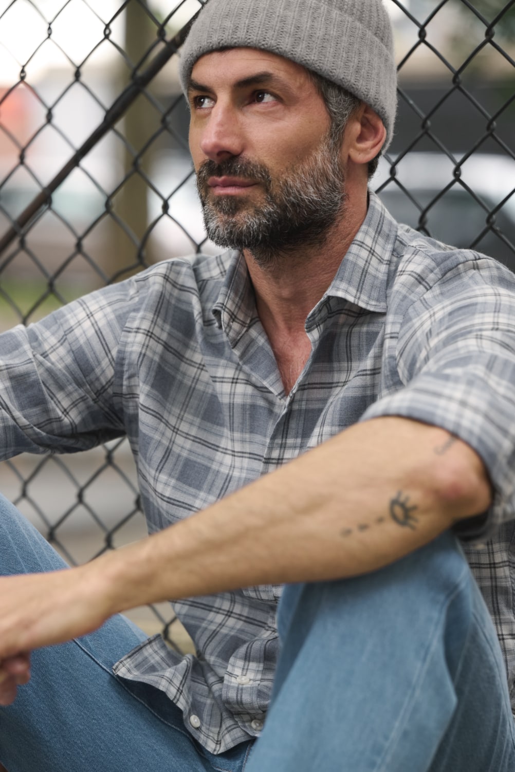 Man leaning against a chain-link fence