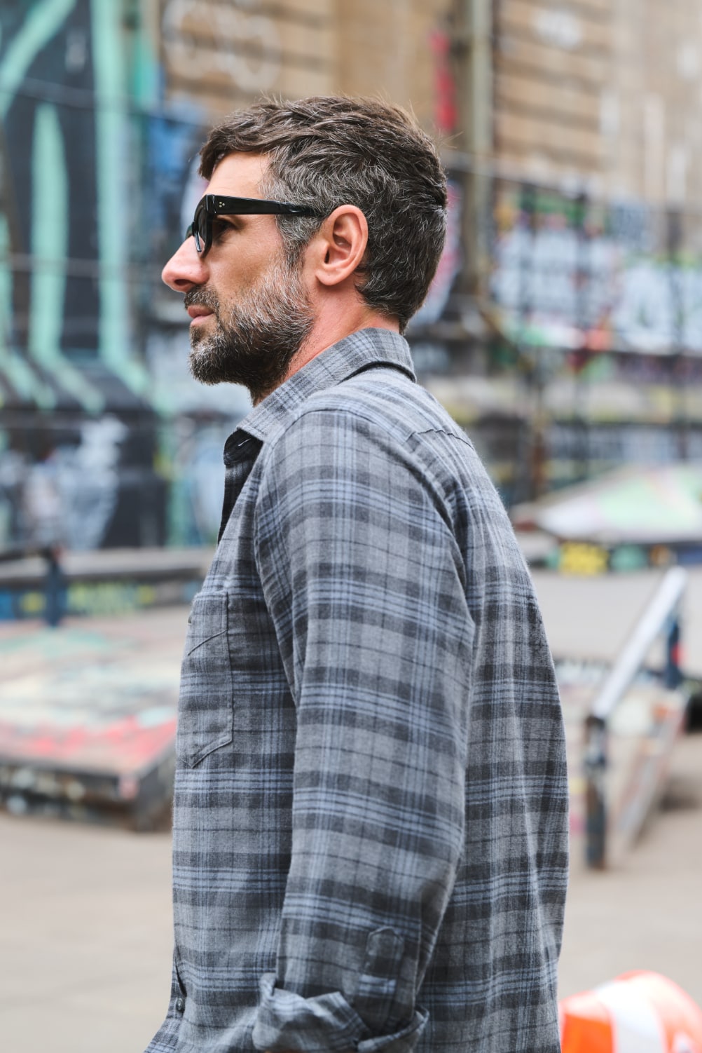 Man in shirt and sunglasses at skatepark