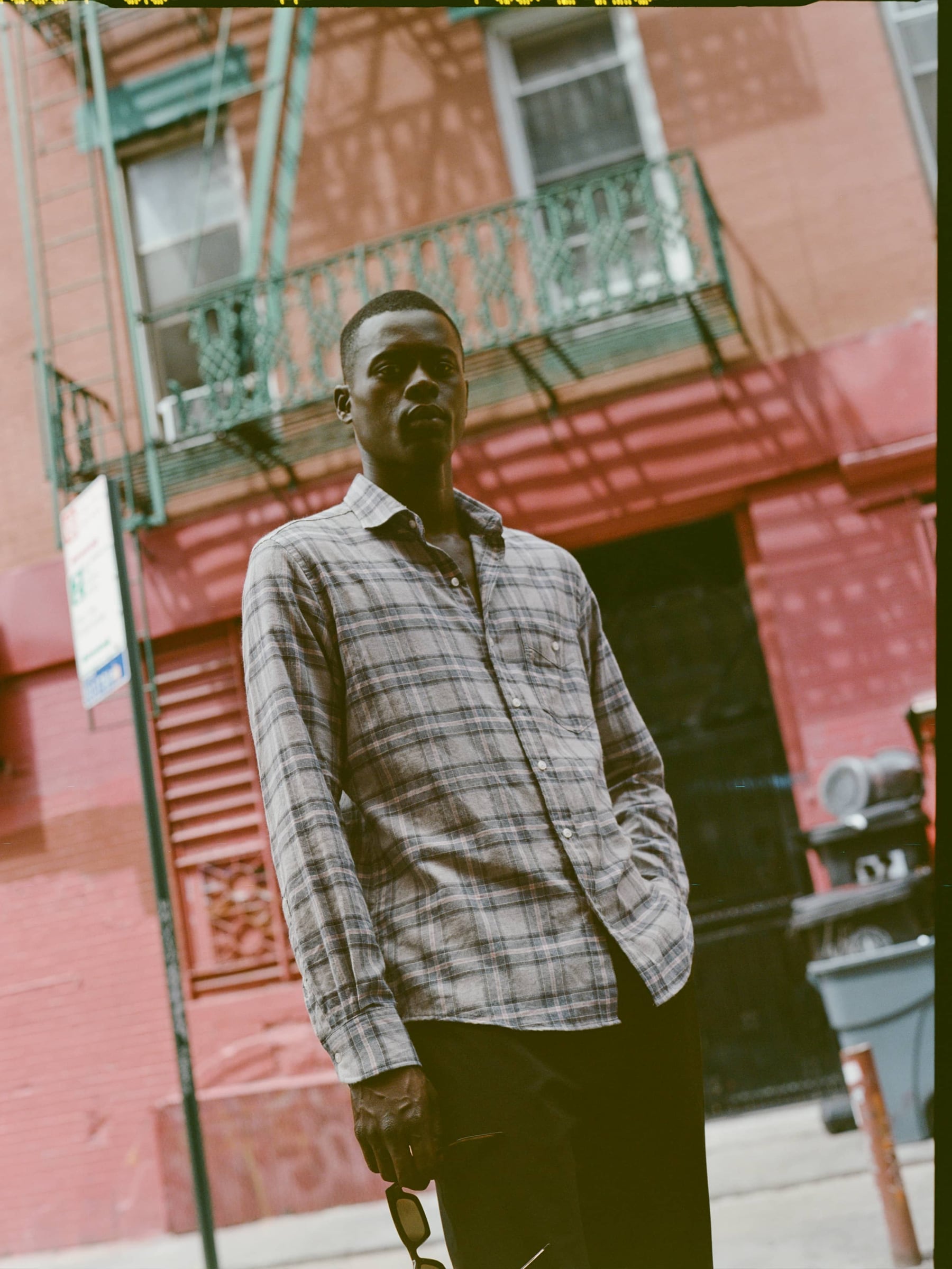 Man in front of fire escape modeling a sage and charcoal shirt