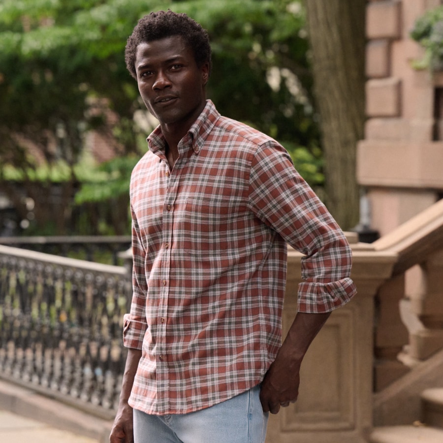 Man wearing a plaid flannel shirt on a sidewalk