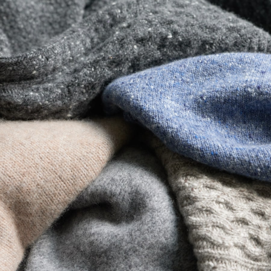 Bundle of soft, colorful sweaters showing a variety of textures.