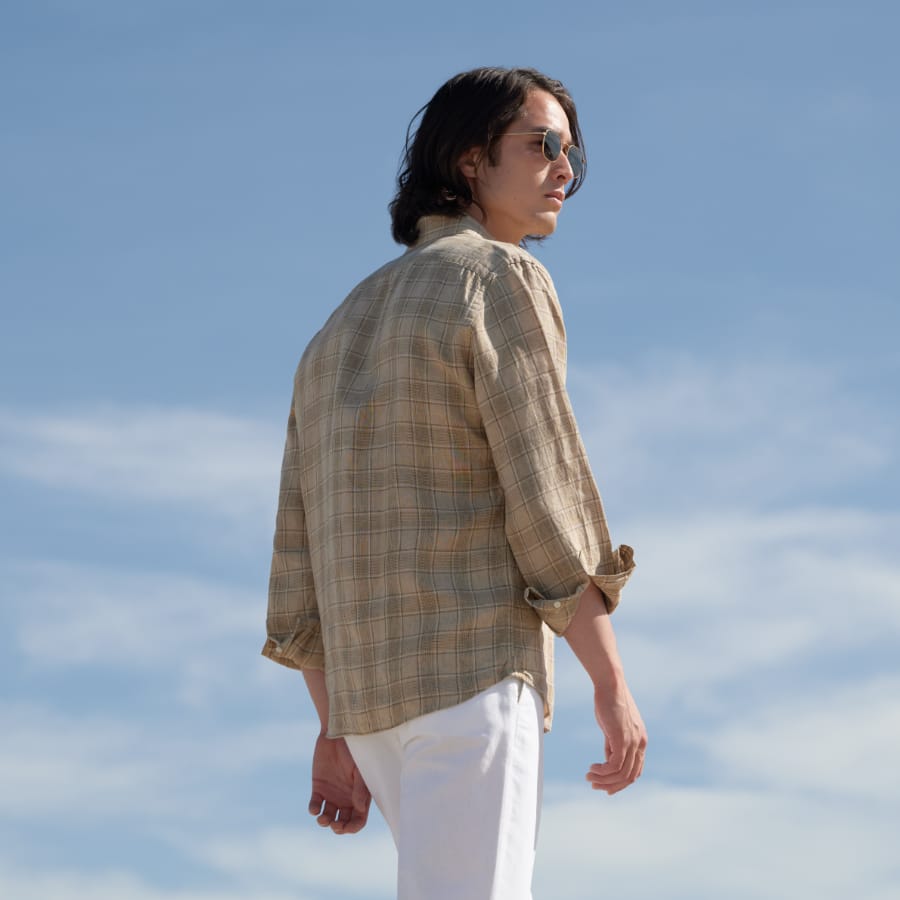 Man wearing custom linen shirt with sky background.