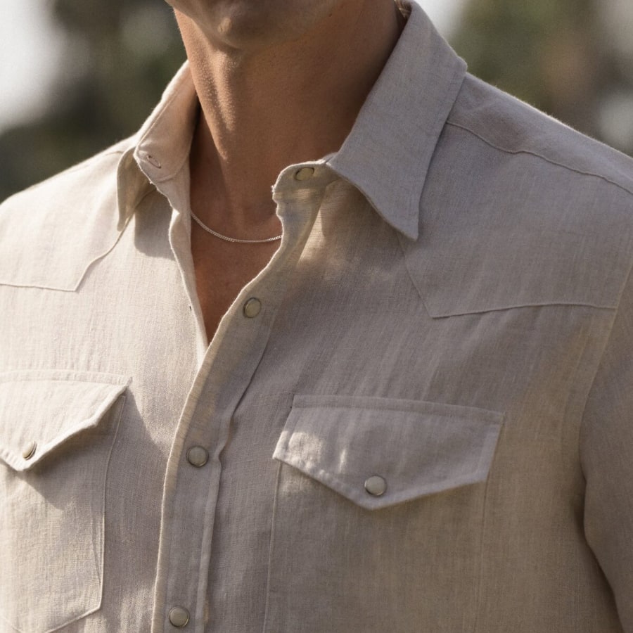 Man wearing custom linen shirt with sky background.