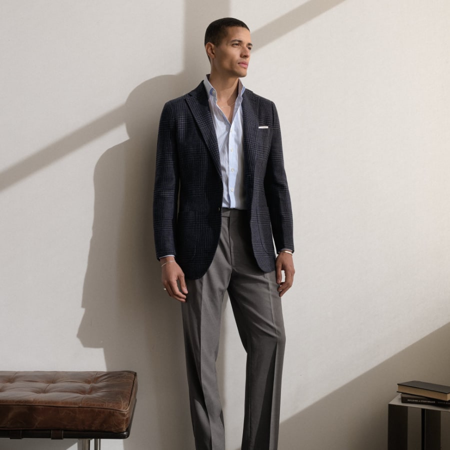 Man wearing a jacket and trouser in a room