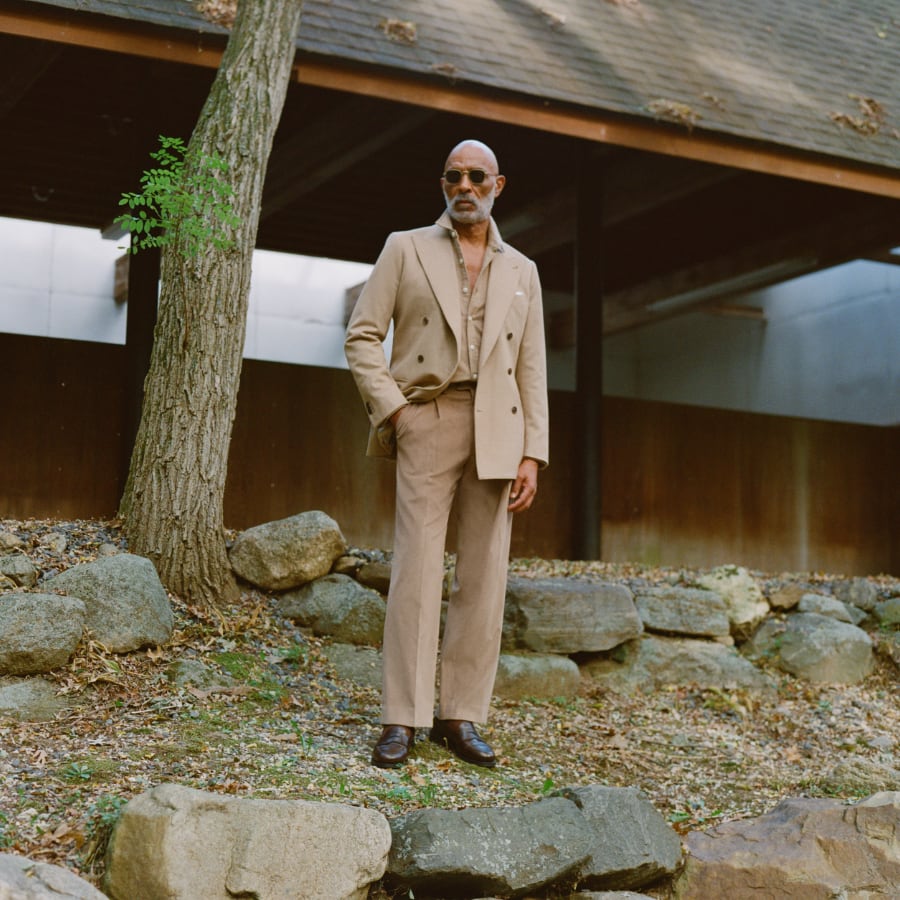 Man wearing suit and overcoat outside in rustic settings