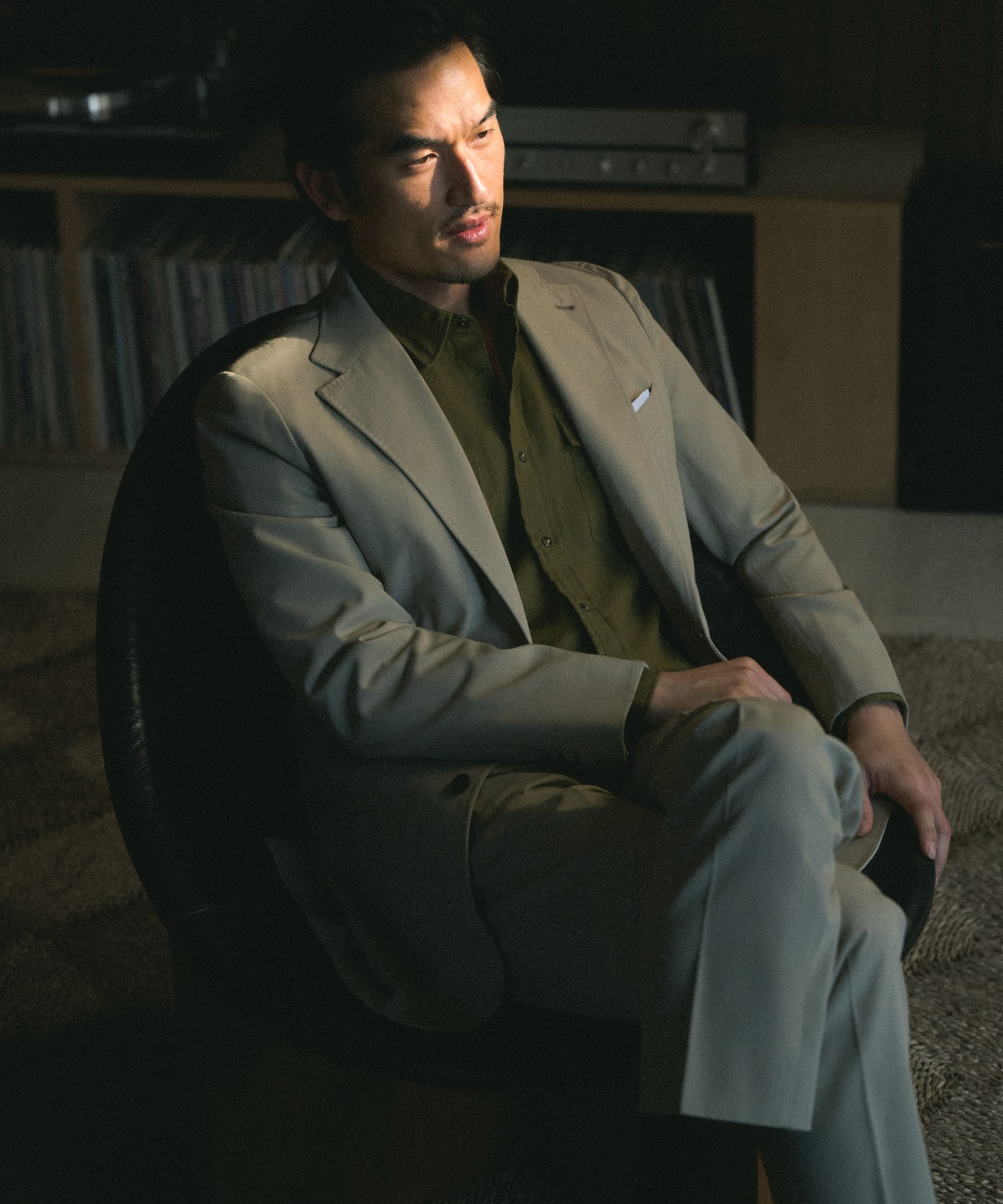 Man wearing a classic gray suit, sitting on a chair