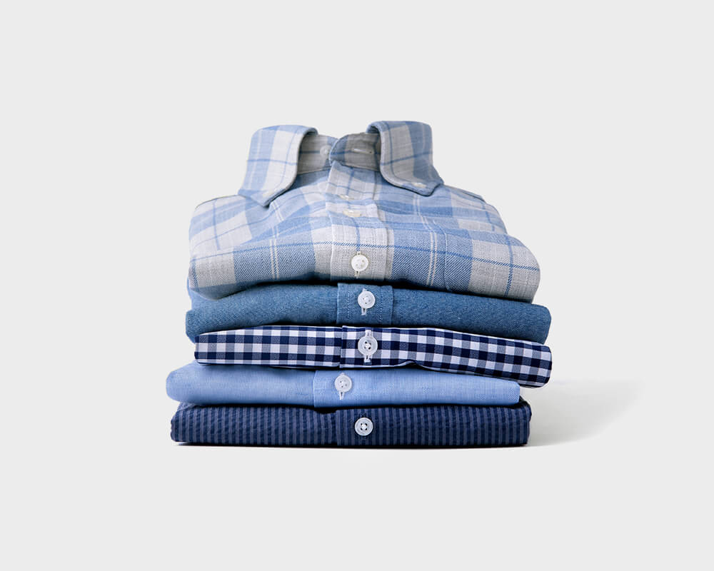 Custom Shirts of Various Colors and Patterns Stacked